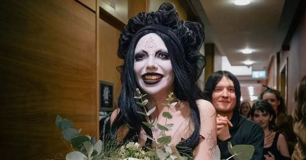 Photograph of non-binary Eurovision contestant Bambie Thug walking with bouquet of flowers