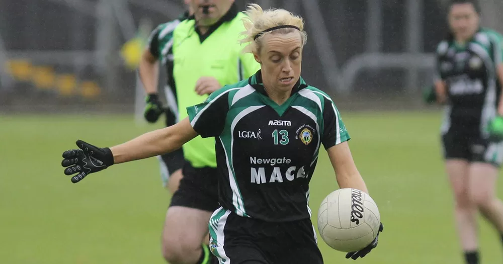 Image of GAA player Geraldine Doherty who is encouraging coming out in the sport. She is playing Gaelic football and wearing a black and green kit.