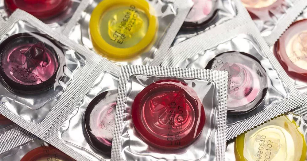 This article is about condoms provided at the Paris 2024 Olympics. Close up shot of various colored condoms.