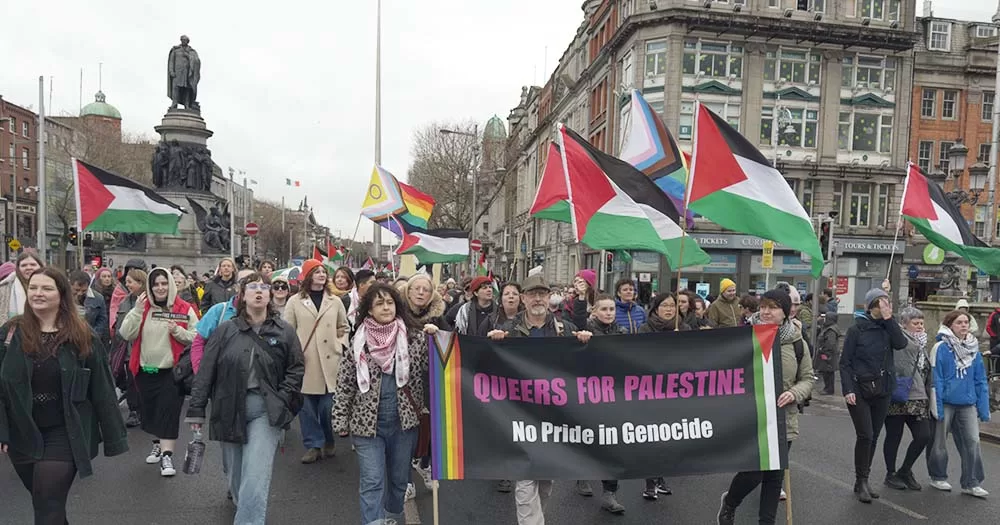 Photo of queer people carrying Pride flags and Palestinian flags