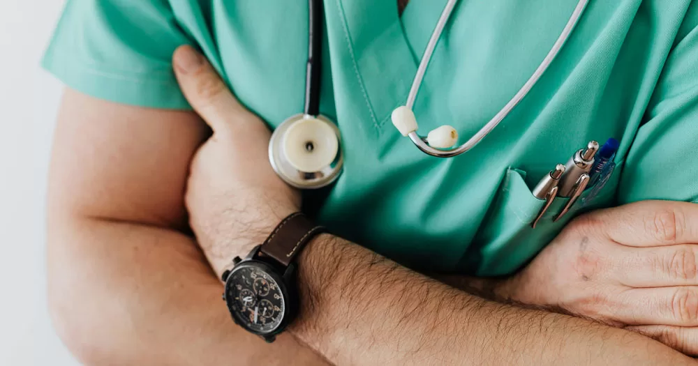 This article is about the US lifting a ban on gay and bisexual men donating sperm. In the photo, the arms of a doctor in his uniform.