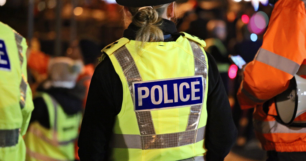 Photo of police from behind wearing a uniform.