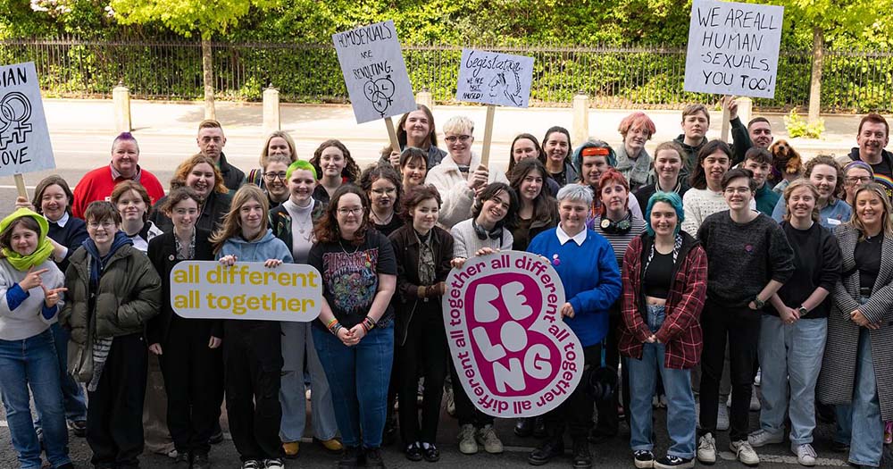 Belong To staff and youth pose with sign celebrating that they are the 2024 Dublin Pride grand marshall.