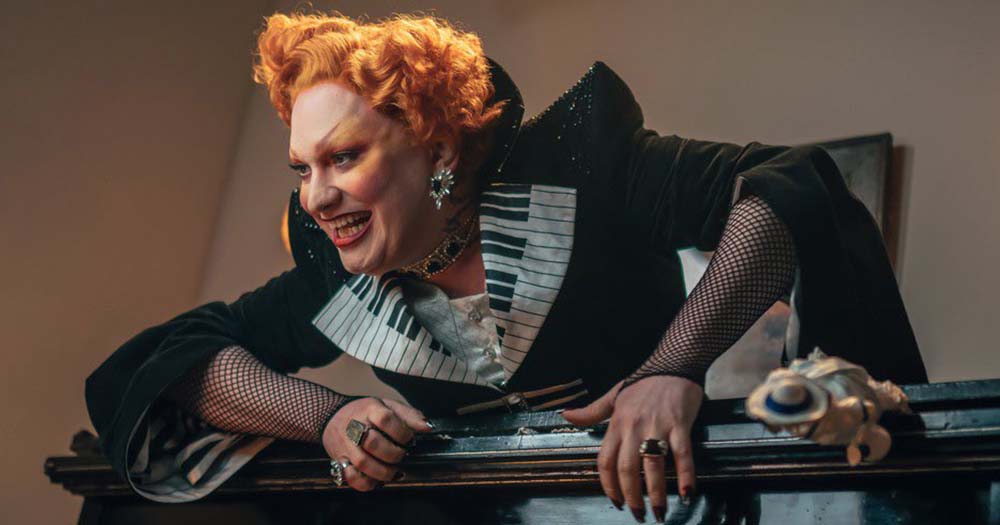 Photo of Doctor Who drag star villain, Monsoon climbing across a piano