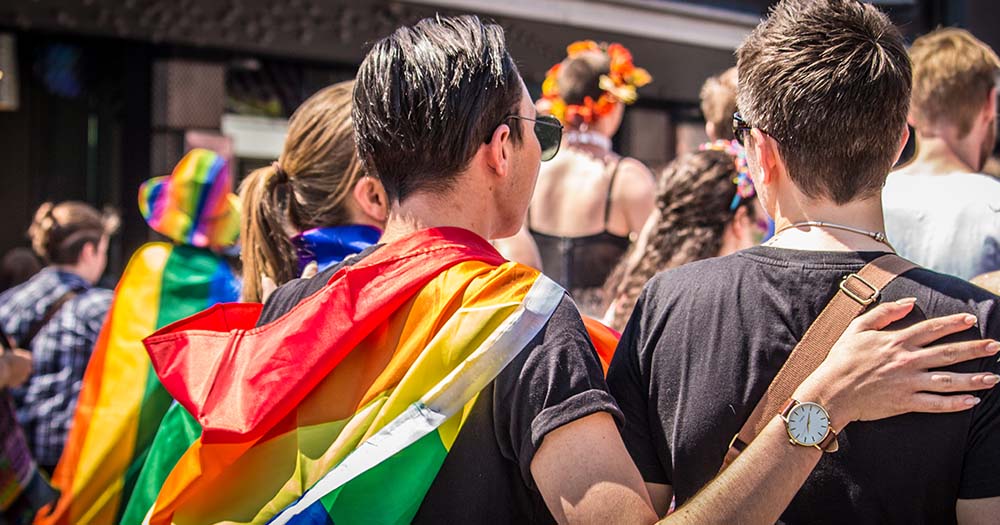 Photo of a person with Pride flag wrapped over his shoulders representing Drogheda Pride 2024