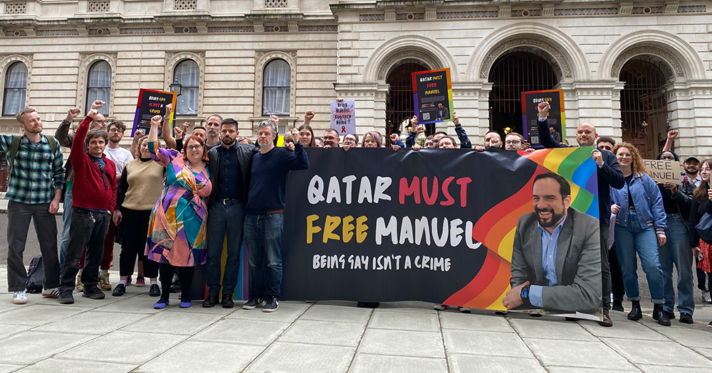 A group of people holding a sign reading "Qatar must free Manuel" - a gay man arrested following an alleged Grindr sting.