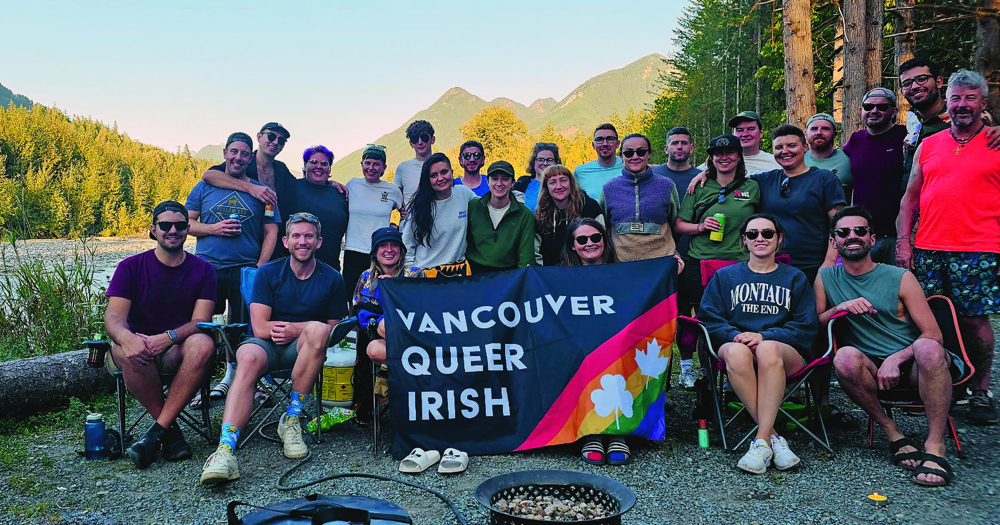 Photo of the Vancouver Queer Irish group, one community formed abroad, as they pose for a photo with a banner with the name of the group.