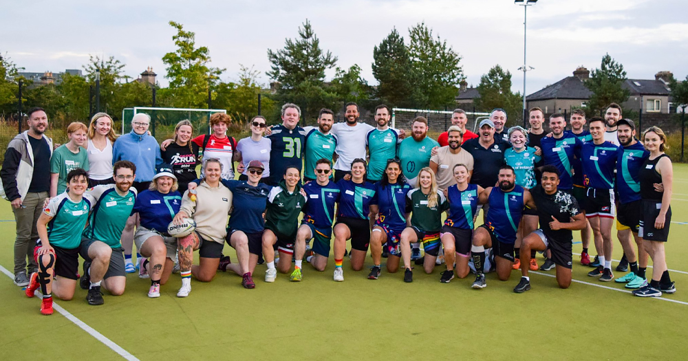 Photo of tag rugby team Naoise, with players posing for a group photo in a field.