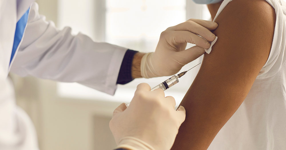 This article is about WHO's declarations about mpox. In the photo, a doctor with a syringe about to administer a vaccine to a patient.