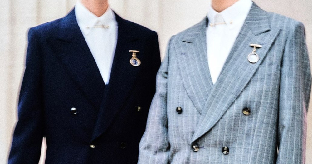 Two suits from Erdem's new collection that debuted at London Fashion Week. Left is a navy blazer with a white shirt buttoned to the top underneath, and right is a grey pinstripe blazer over a white shirt buttoned to the top.