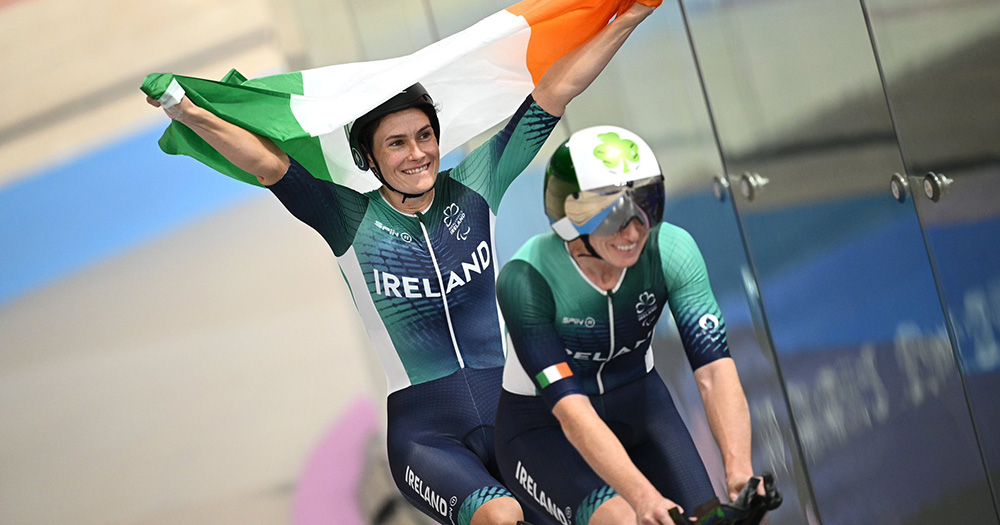 Katie-George Dunlevy and Eve McCrystal doing a lap of honour in the velodrome at the Paris 2024 Paralympic Games.