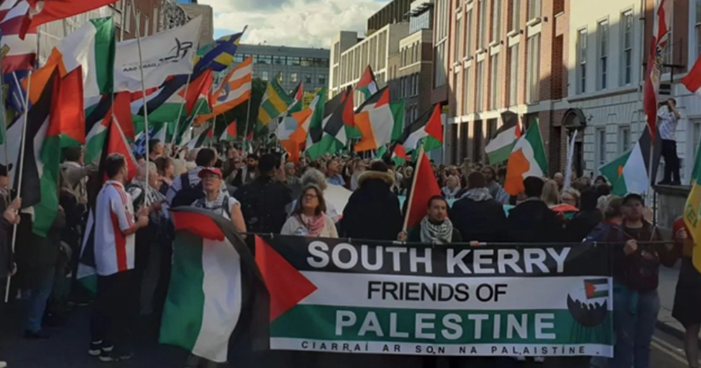 This article is about activists calling for the enactment of the Occupied Territories Bill. Image shows participants holding a banned reading 'South Kerry Friends of Palestine'.