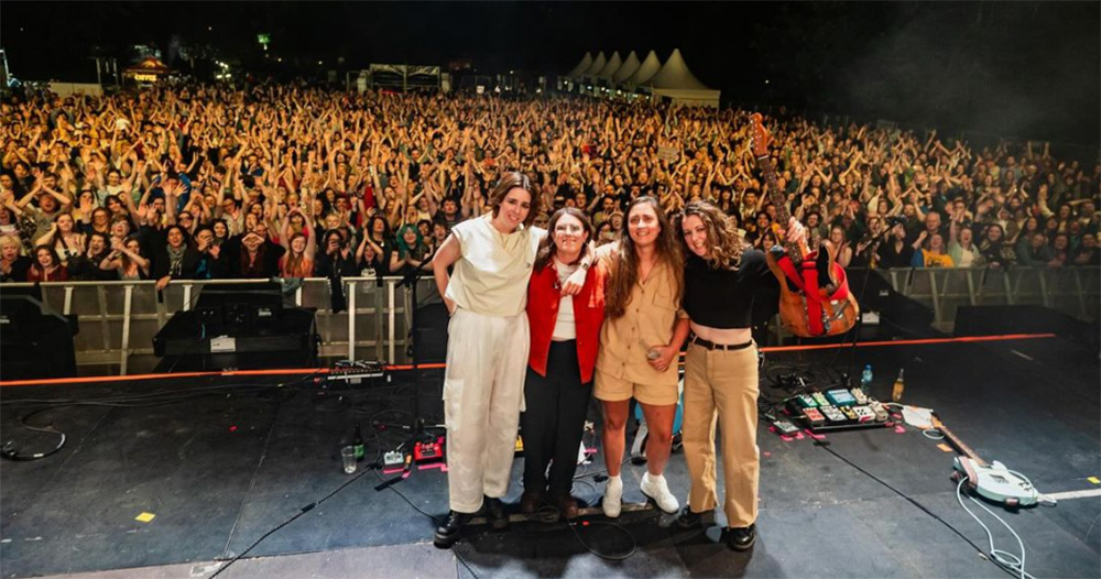 Pillow Queens, who are the headliners of a West Ireland music festival, posing for a photo with a crowd of fans in the background.