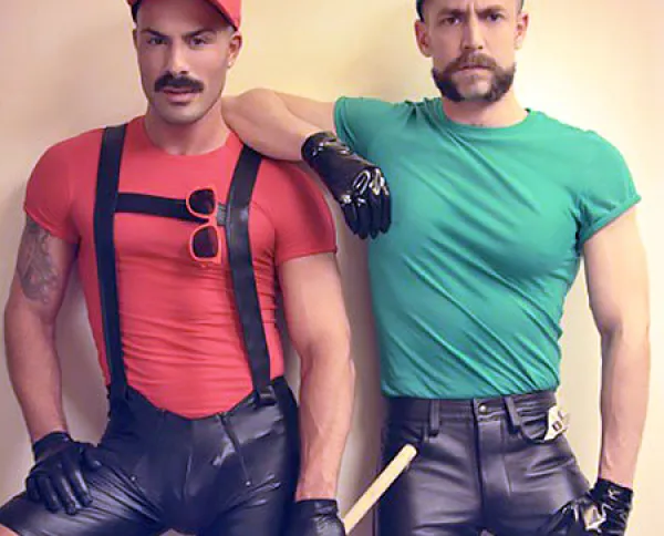 This costume is inspired by Mario and Luigi so the two men pictured are dressed as Mario and Luigi. One is wearing a red shirt and cap, the other one a green shirt and cap and both have moustaches.