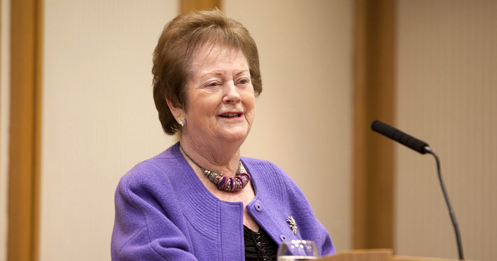 Photo of politician Mary O'Rourke talking to a microphone while wearing a purple cardigan.