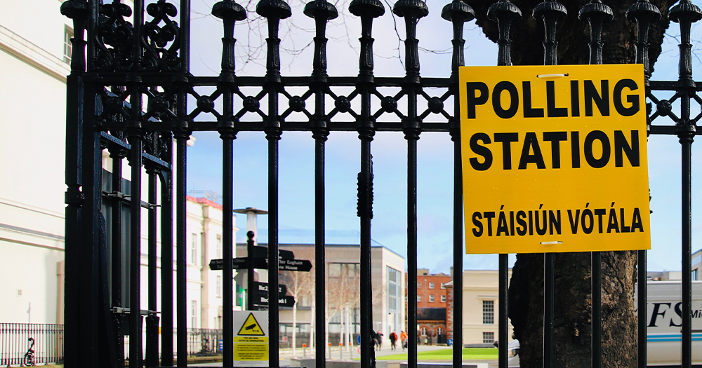 This article is about the 2024 general election in Ireland. In the image, a yellow sign that reads 'polling station' hanging on a fence.