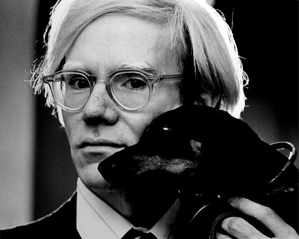 A photo of the artist Andy Warhol with Archie, his pet