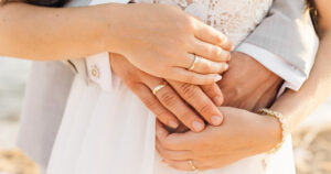 This is an article about the trend of friendship marriages in Japan and how the LGBTQ+-community can benefit from it. Pictured are two people, husband and wife, who got married and are displaying their wedding rings while holding hands.