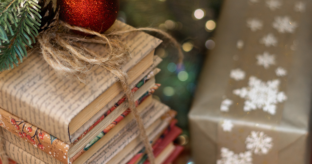 A Christmas holiday themed image with books gift wrapped and other presents visible.