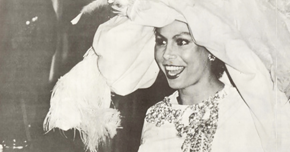 Black and white photo of Lady Java, wearing a big hat and smiling.