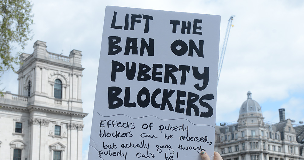 Northern Ireland has banned puberty blockers for under-18s. The image is of a protest sign reading "Lift the ban on puberty blockers".