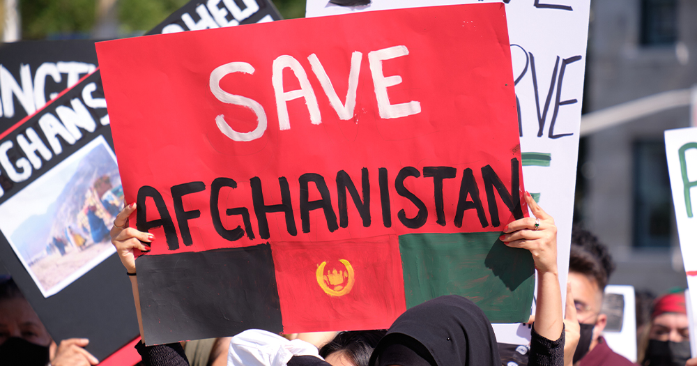 This article is about the international Criminal Court mentioning LGBTQ+ people in a case against Afghanistan. In the photo, protesters carrying signs that read "Save Afghanistan".