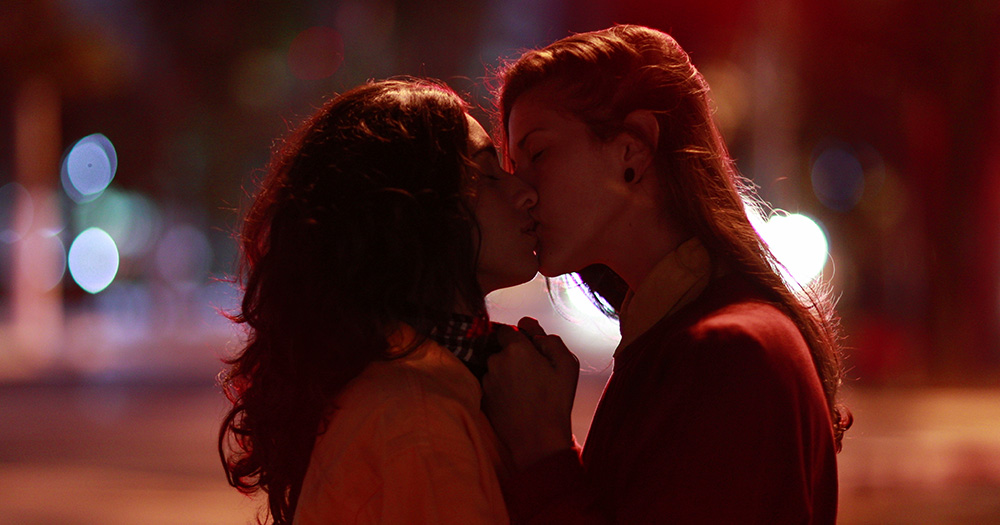 This article is about lesbian cruising. The image shows two women kissing on a dark street.