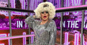 An image of late drag queen Heklina. She wears a sparkly silver dress and and big blonde wig.