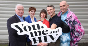 This article is about a new campaign to tackle HIV stigma in Ireland. In the photo, HIV activists holding a sign that reads You Me and HIV.