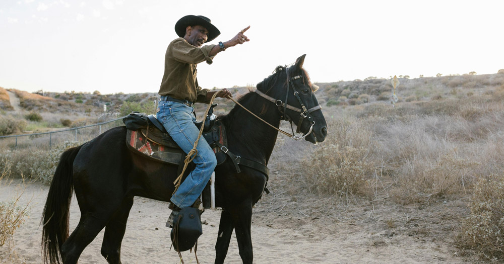 Queer cowboy riding a horse