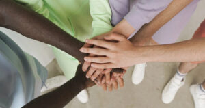 This article is about the Rainbow Award. In the photo, the hands of young people holding them together.