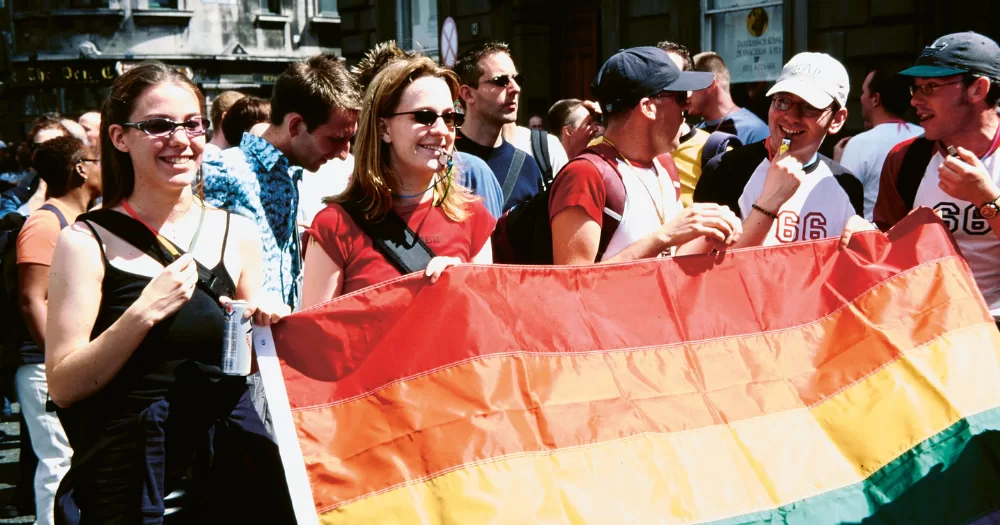 Image from the Irish Queer Archives shows people holding a pride flag