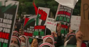 Protestors hold signs in support of Palestine.
