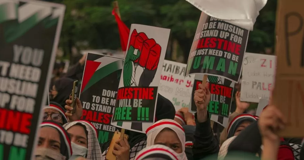 Protestors hold signs in support of Palestine.