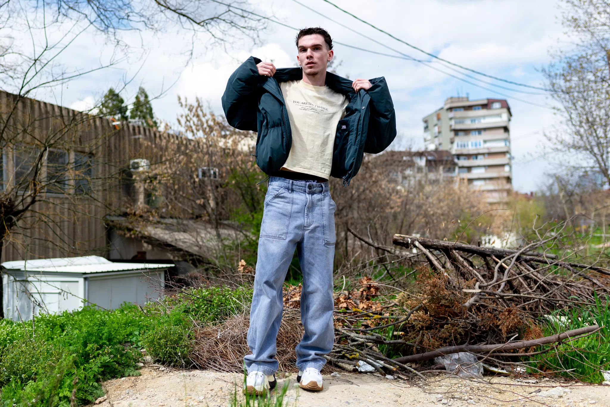 A young man poses surrounded by a Balkan city.