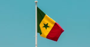 The flag of Senegal infront of a blue sky
