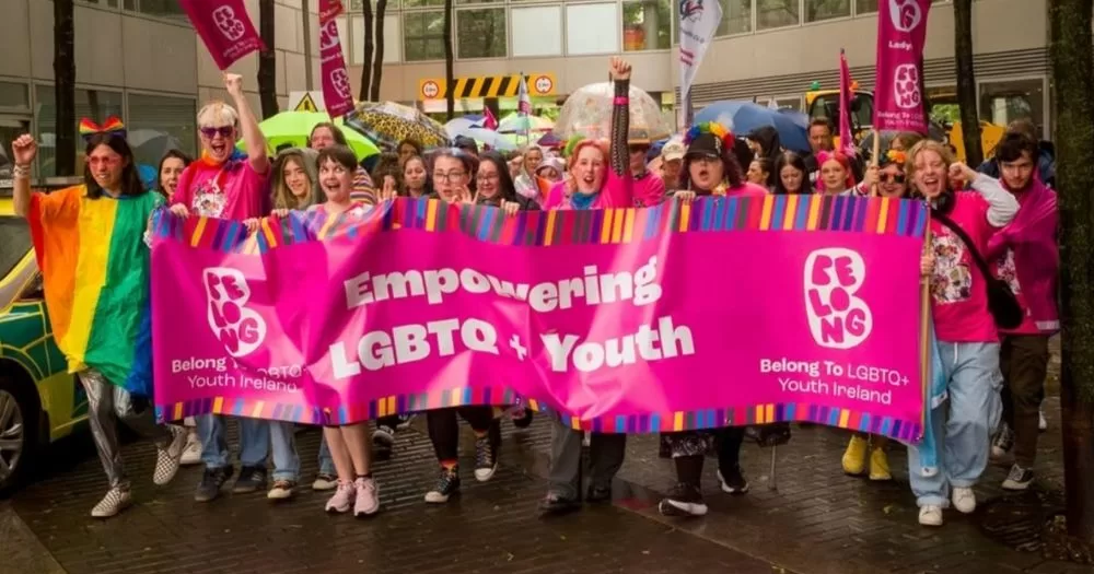 Belong To youth club celebrating Pride behind a large banner.They have recently been nomintaed for a community funding award
