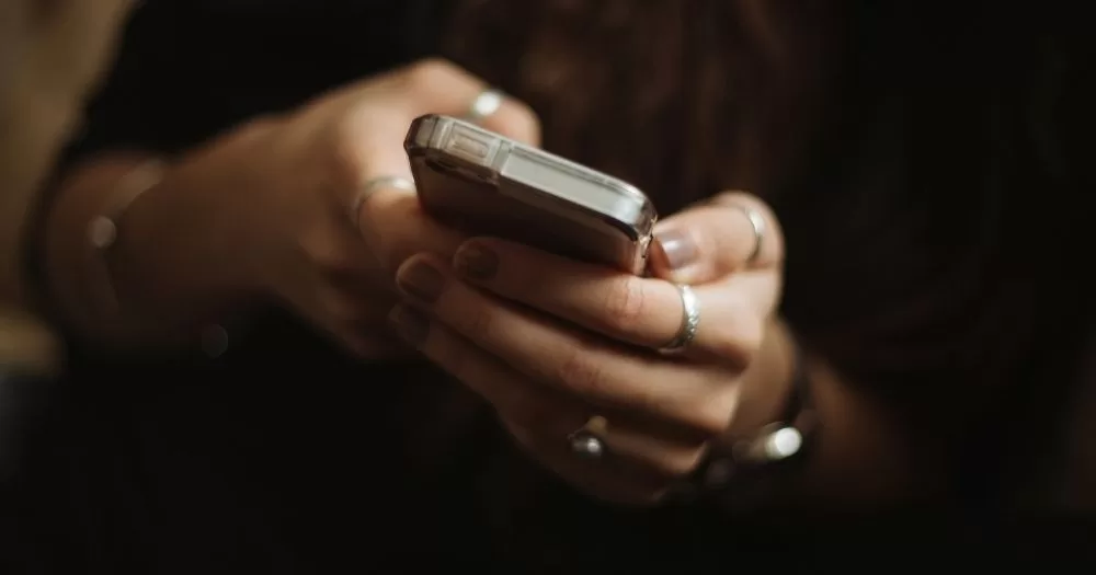 A person using a phone. This image is being used to accompany an article about Grindr blocking location access in the Olympic Village.