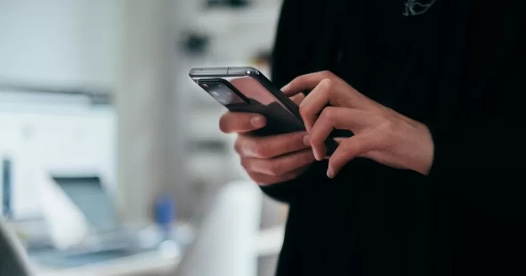This article is about image-based sexual abuse. in the photo, a person holding a phone and typing.
