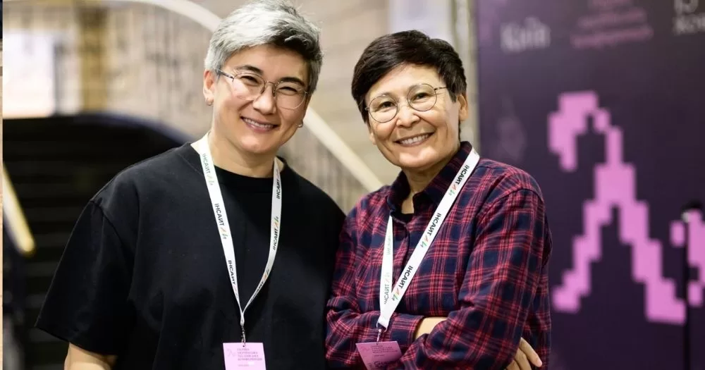 Feminist and lesbian activist Zhanar Sekerbayeva (left) stands beside another activist at a conference.